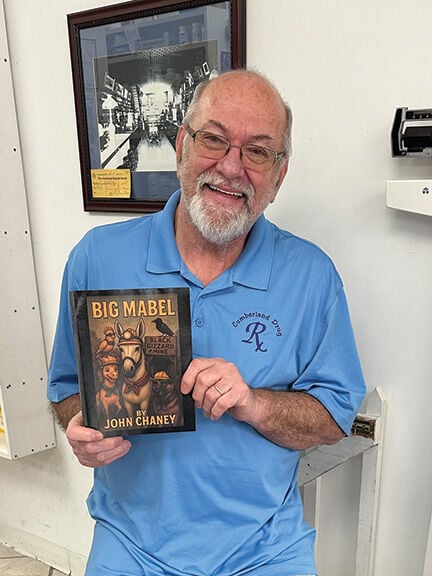 John Chaney holding his book Big Mabel at Cumberland Drug